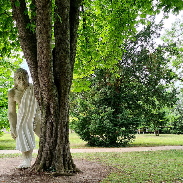 Statue eines Riesen neben Baum.