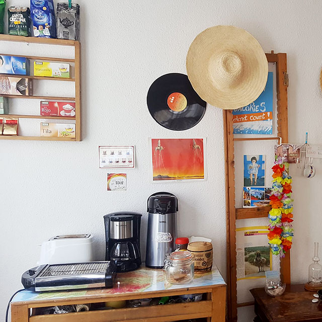 Wohnzimmer in Hostel mit Kaffe- und Teekanne auf Tisch und Hüten an der Wand.